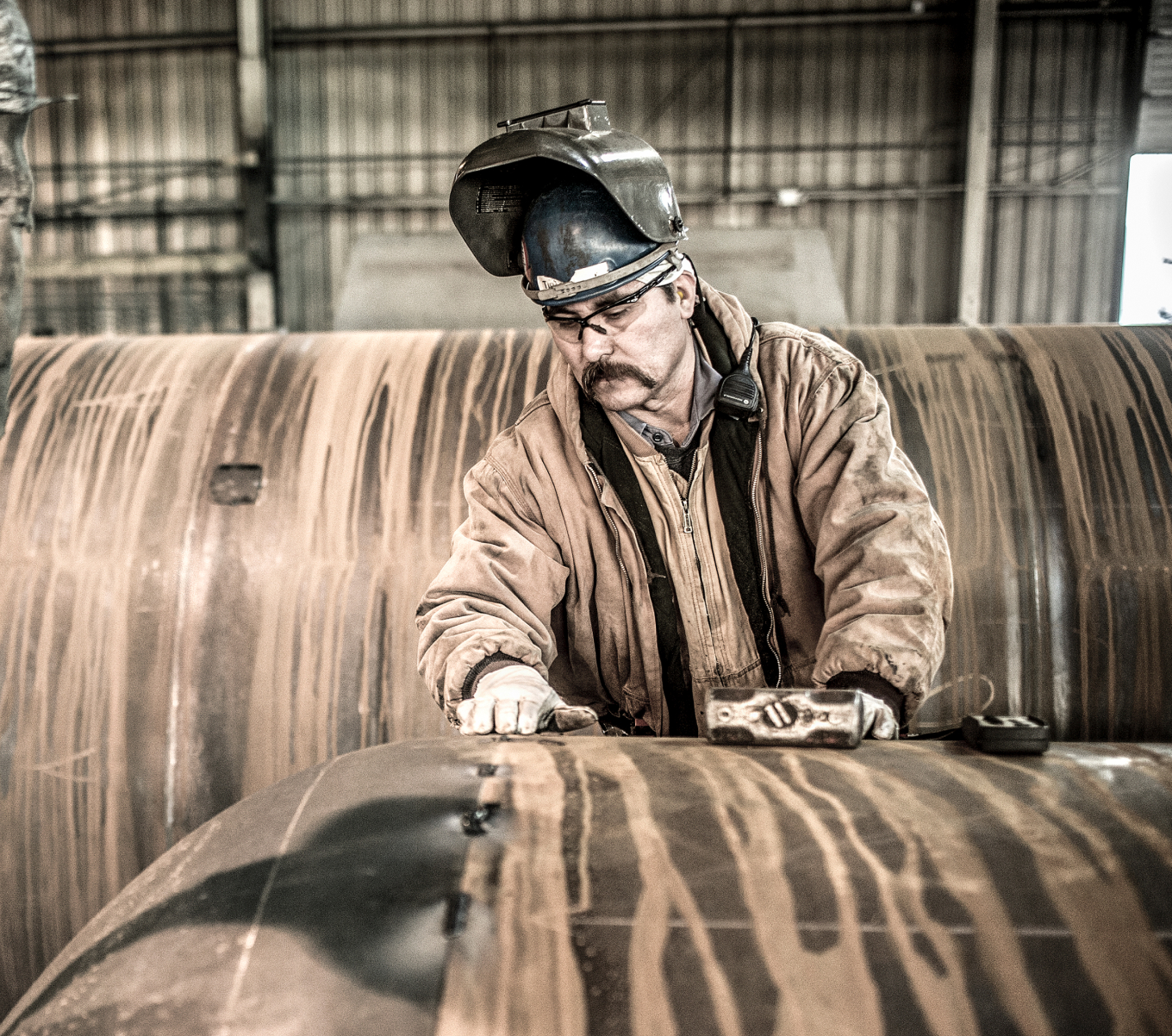 A welder works on a rail part