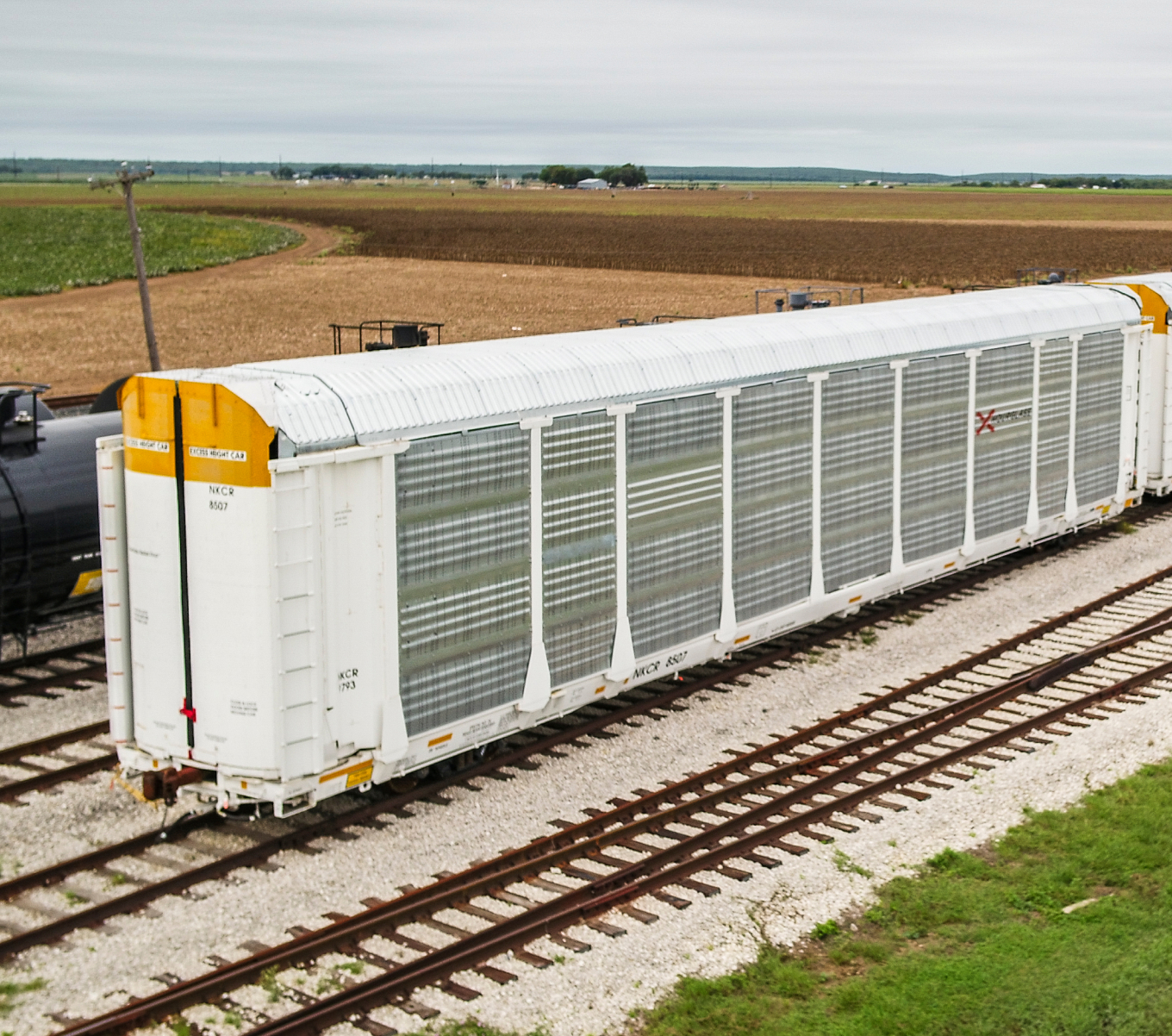 A white autorack car sits on a track