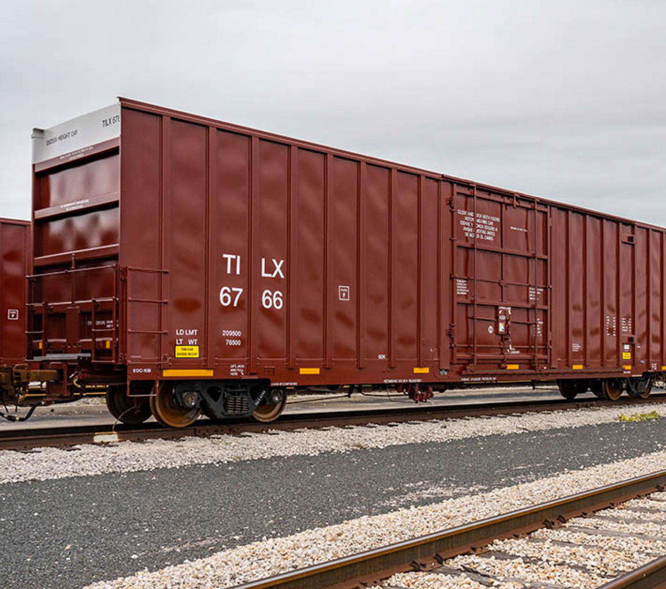 A red box car sits on a track