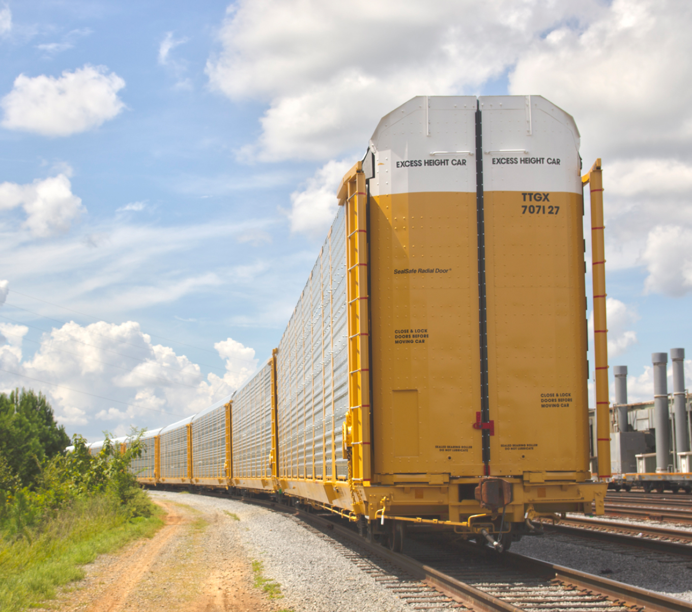 A line of yellow, tri-level autorack cars